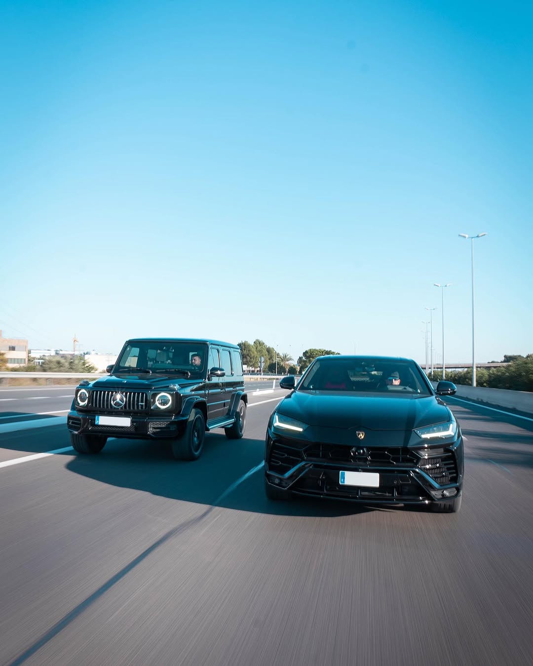 Mercedes-AMG G63 y Lamborghini Urus negros por autovía