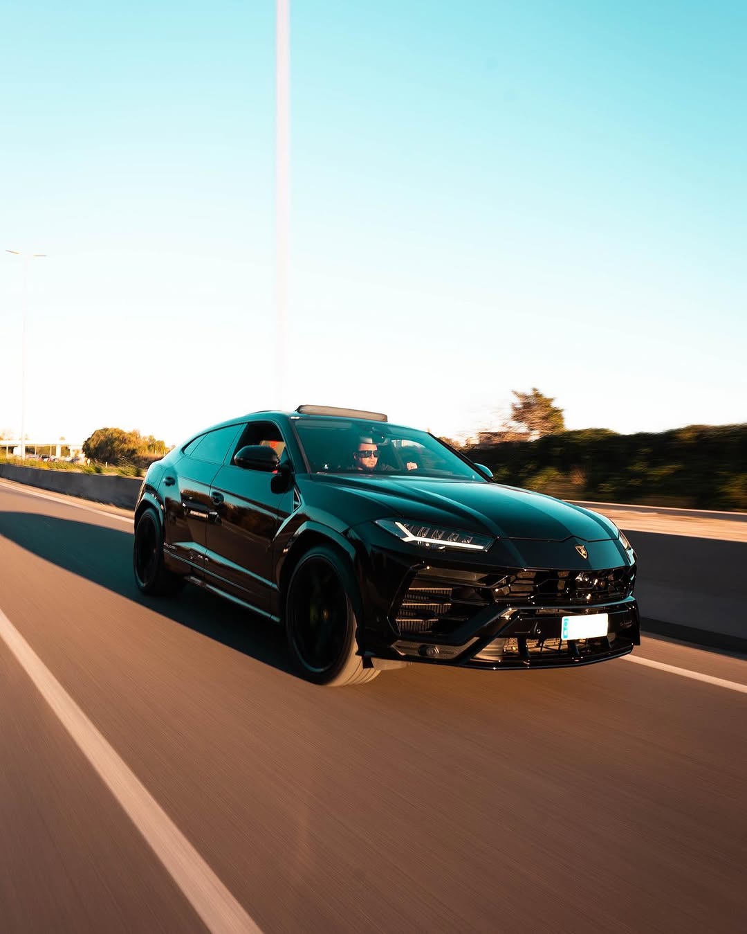 Lamborghini Urus negro en marcha con techo abierto